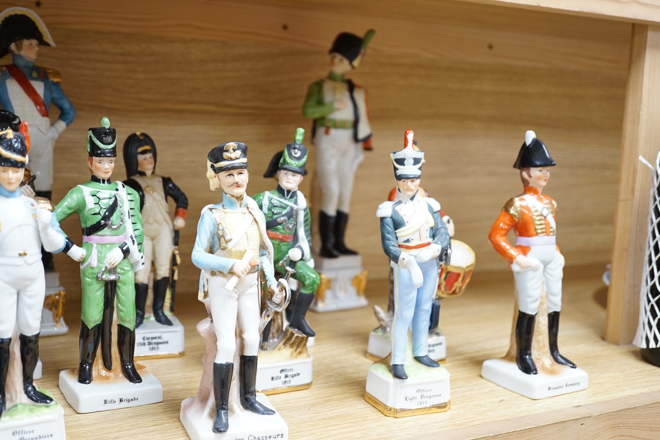 Twenty porcelain figures of soldiers including Officer Light Dragoon and Rifle Brigade, largest 31cm high